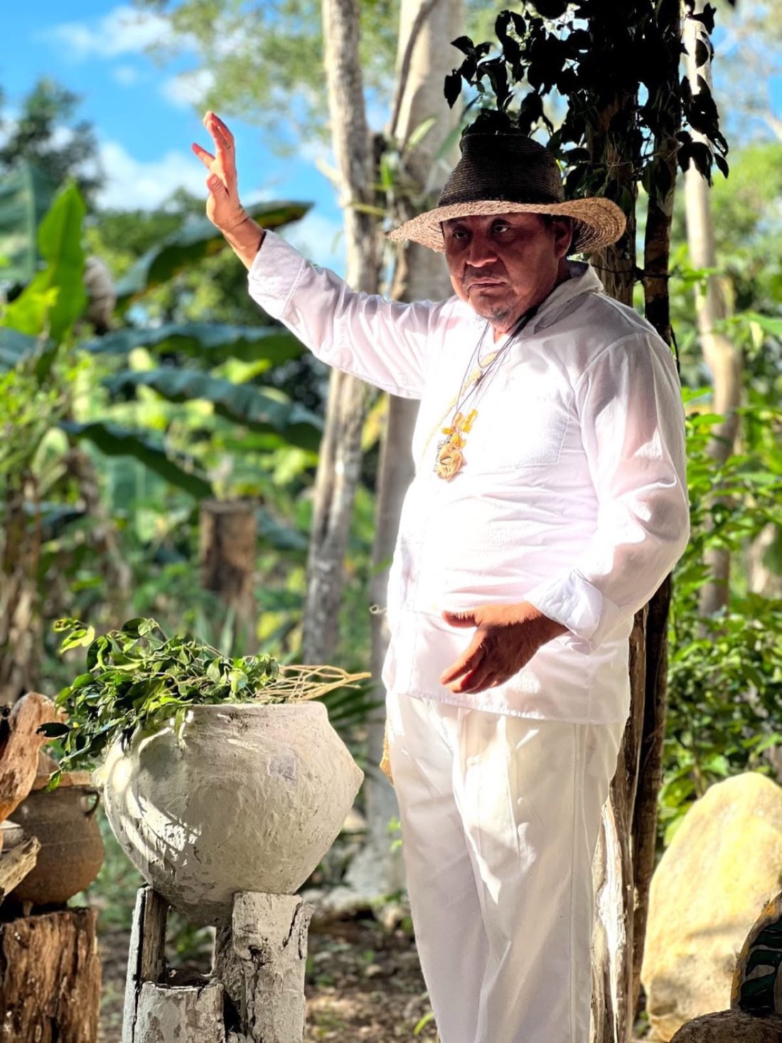Maya elder in white leading a jungle ceremony
